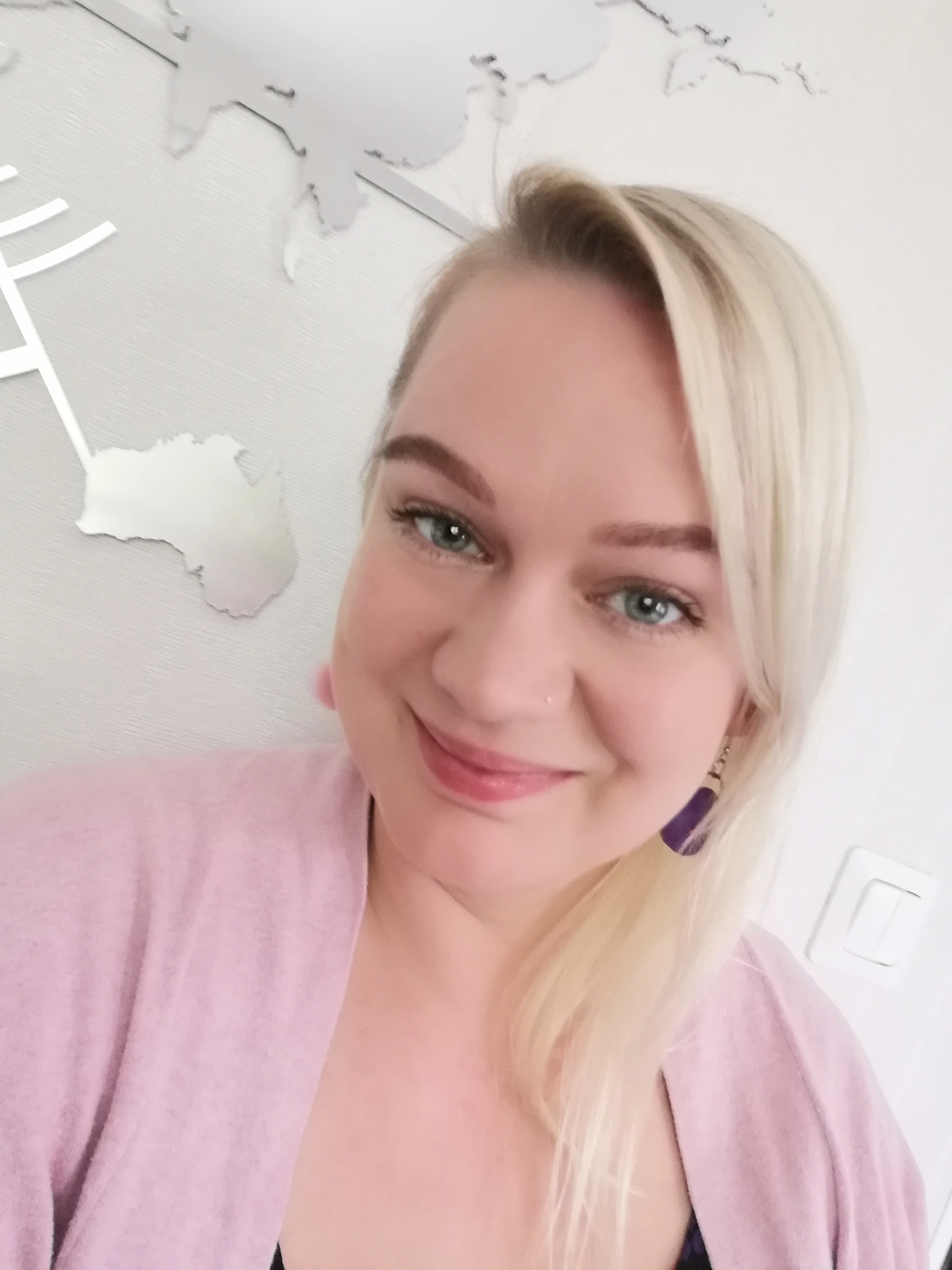 Sini_Verkkovalkyrie_virtuaaliassistentti Sini assa verkkovalkyrie vaalea nainen katsoo kameraan ja hymyilee