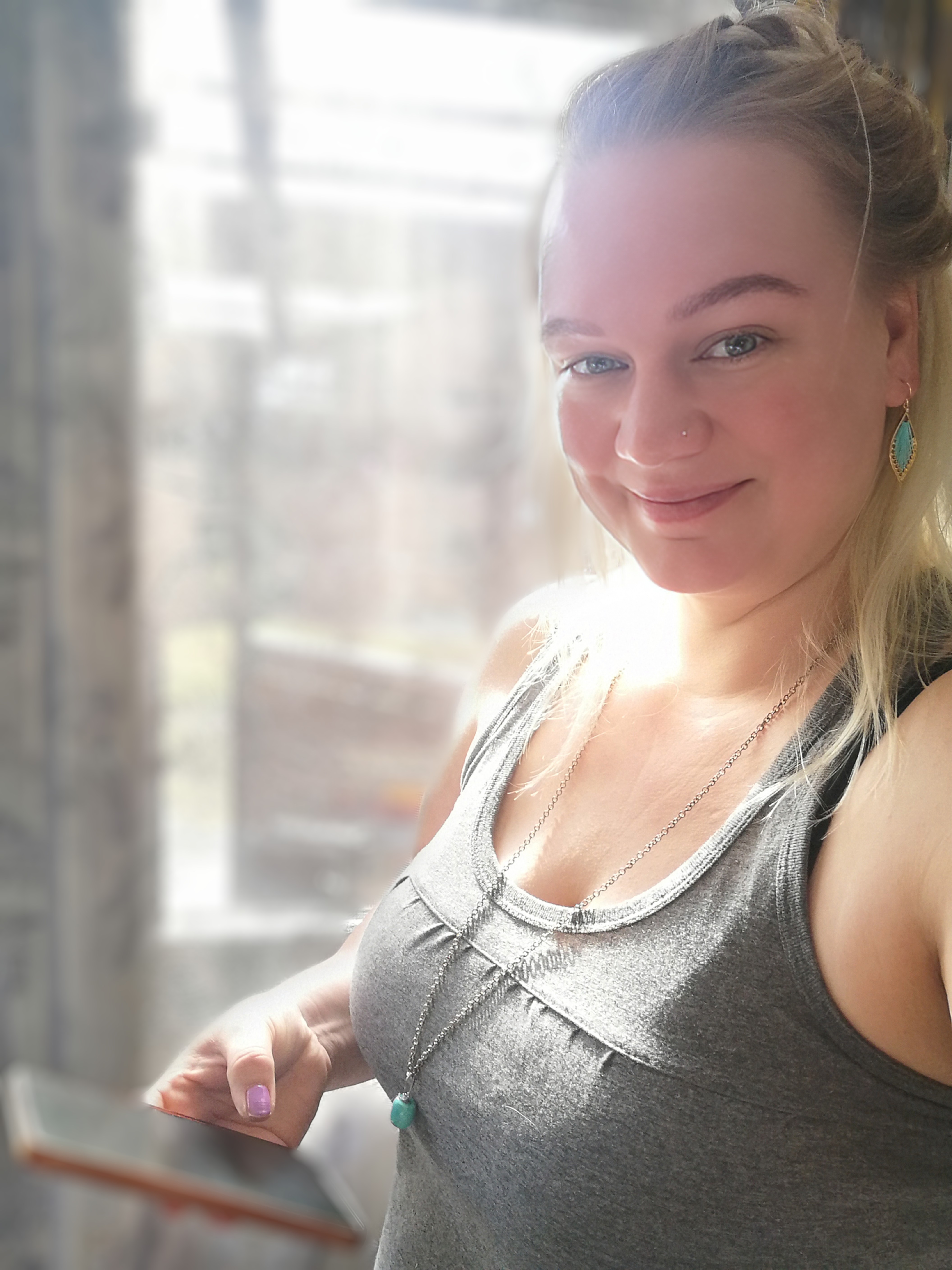 Verkkovalkyrie_sini_etäapuri nainen katsoo kameraa ja hymyilee puhelin kädessä