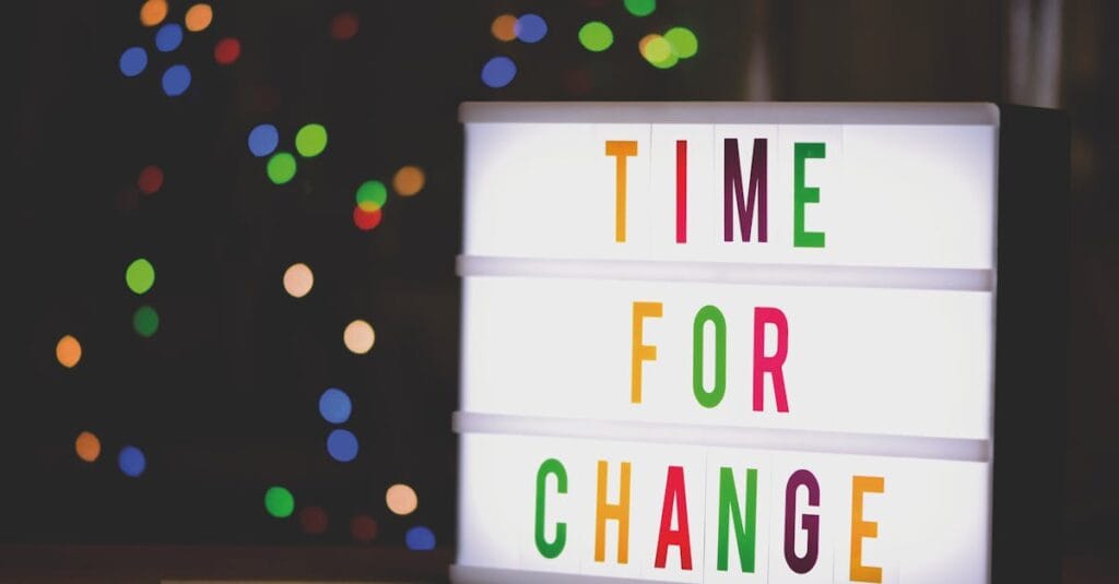 pexels-photo-2277784-2277784 Colorful illuminated sign displaying the motivational message 'Time for Change'.