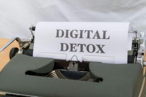 Close-up of a typewriter with paper showing 'Digital Detox', emphasizing a tech-free lifestyle._Yrittäjän_dig_arjen_kuormitus