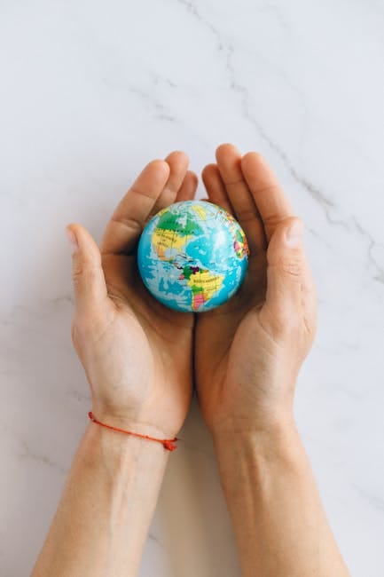 pexels-photo-7235805-7235805 Close-up of hands gently holding a small globe representing global unity and care.